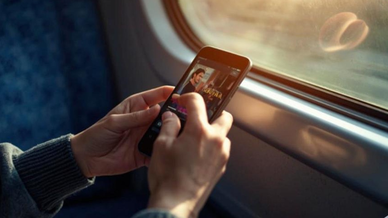 Pessoa assistindo novela turca no celular durante viagem de trem